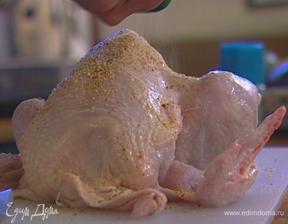 Чеснок раздавить плоской стороной ножа и начинить им разрезы в мясе, пару раздавленных зубчиков положить внутрь тушки, посолить, поперчить и посыпать приправой к курице со всех сторон.