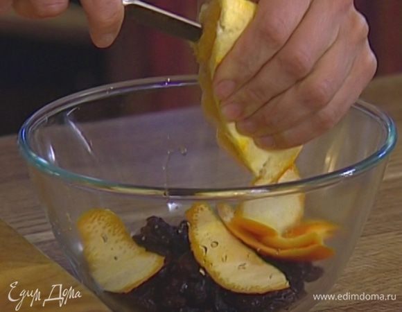 Изюм залить апельсиновым соком, добавить половину срезанной с апельсина цедры, 2–3 ст. ложки кипятка и все перемешать. 