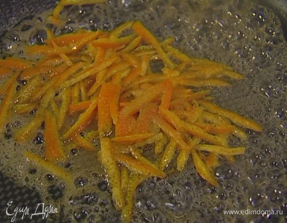 Разогреть сковороду, выложить измельченную цедру, добавить 1 ст. ложку сахара и 3 ст. ложки жидкости, в которой замачивается изюм, и все закарамелизировать. 