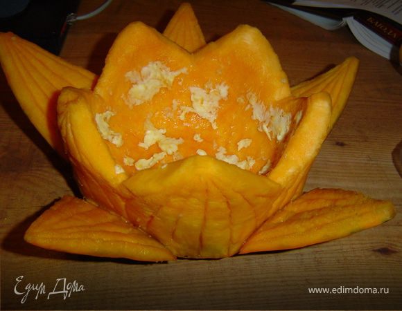 Начинаем процесс с изготовления цветка из тыквы, для этого срежьте у тыквы верхушку, ложкой выскоблите мякоть, оставляя стенки толщиной 2,5 - 3 см. Острым ножом сделайте пять глубоких надрезов на внешней стороне тыквы.Каждый из пяти надрезов обрежьте в виде треугольников.На внутренней стороне надрезов карбовочным ножом сделайте выемки в виде жилок. А мякоть тыквы обрежьте в виде лепестков.На внешней стороне "лепестков" сделайте выемки в виде жилок.Тыкву смажьте внутри сливочным маслом и натрите чесноком, поместите на противень, на который налейте немного воды, и отправьте в духовку, которая разогрета до 180°С. Запеките тыкву до мягкости.