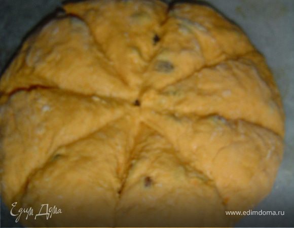Сформировать круг, положить его на противень, застеленный бумагой для выпечки, и сделать ножом 8 глубоких надрезов.
