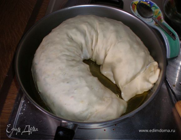 В большой сковороде разогреть оливковое масло (на умеренном огне, т.к.пирогу предстоит провести много времени на ней и если его положить на раскаленную сковороду - тесто быстро подгорит, а начинка останется сырой.)Масло должно быть достаточно. Выложить пирог на сковороду и на медленном огне жарить~30 минут с одной стороны (смотрите по цвету - зажаристый должен быть), перевернуть и жарить столько же с другой стороны.Смотрите чтобы масло немного шевелилось, шкварчало под питой,это правильная температура. 