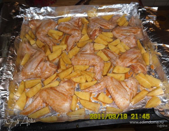 Перемешиваем и оставляем мариноваться.У меня они стояли пять с половиной часов. 
Картофель разрезаем на маленькие дольки. 
Противень застилаем фольгой, смазываем тонким слоем раст. масла и выкладываем крылышки.Картофель обмазываем оставшимся маринадом и тоже выкладываем 