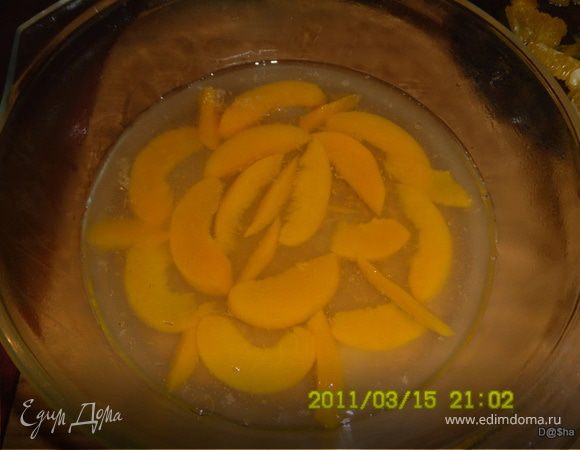 Залить желатин стаканом воды и дать набухнуть,затем распустить его на водяной бане(на маленьком огне) не дав закипеть,добавить к нему сироп из банки, сок лимона,воду,сахар(если нужен).Все хорошенько перемешать. 
Персики порезать ломтиками,апельсин разрезать пополам. Из одной половинки выжать сок,а вторую почистить,чтобы осталась одна мякоть(без белых пленок). 
В форму уложить половину персиков и залить желейной массой,чтобы чуть покрывала их.Тогда они не поплывут.И поставить застывать в холодильник(я ставила в морозилку,чтобы быстрее). 