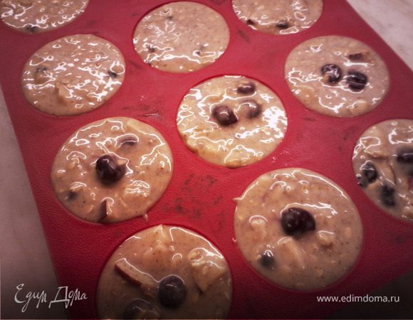 Добавить соду, кефир, яйцо, масло, порезанное яблоко, вишню (или изюм). Хорошо перемешать. Выложить в формочки. Выпекать при температуре 180 градусов 30-40 минут (проверять зубочисткой).