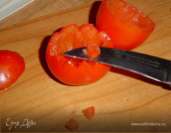 Разрежьте помидор поперек на две части, большую и меньшую. Ложечкой извлеките из него сердцевину. По краю большей части помидора вырежьте зубчики.