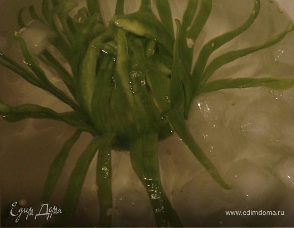 У перца удалите сердцевину с семенами. Сделайте много надрезов от кончика до плодоножки, не дорезая до конца. Мякоть образовавшихся лепестков расслоите на две части. Если мякоть разрежете ближе к кожице - то внешние лепестки свернутся. Если разрежете по середине - то лепестки будут прямыми. Поместите перец в ледяную воду и отправьте в холодильник на 1-2 часа, чтобы перец приобрел вид цветка.