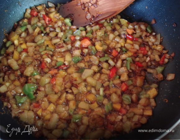 А в это время приготовьте начинку. Очистите и нарежьте кубиками баклажаны. Нарежьте мелко лук, натрите на терке морковь и обжарьте на растительном масле. К луку и моркови добавьте баклажаны и нарезанный кубиками сладкий перец. Посолите и поперчите по вкусу. В готовую начинку добавьте мелко нарезанную зелень.