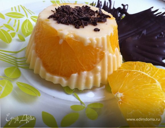 крахмал смешать с сахаром и добавить в него 4 ст ложки холодного молока, смешать. Остальное молоко довести докипения. Добавить апельсиновую эссенцию. Снять с огня, влить крахмальную смесь и снова поставить на огонь. Помешивая довести до кипения и кипятить 1 минуту. Силиконовые формочки ополоснуть холодной водой. Не вытирать. По стенкам формочкек выложить апельсиновые дольки. Влить горячую молочную смесь. Убрать в холодильник до полного остывания. Достать из формочки, украсить шоколадной крошкой. Подавать с апельсинами.