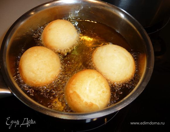 Разогреть в кастрюльке или ковшике масло (не должно быть перегретым, температура должна быть ровной), сделать огонь или мощность средней. Проверить степень накаливания масла можно небольшим кусочком теста, кинув его в кастрюльку - оно должно практически сразу подняться, не прилипать ко дну. В противном случае шарики впитают в себя много масла.
Жарить порциями наши шарики до красивого золотистого цвета. Если мало разогрето правильно, переворачиваться они будут сами.
Готовые шарики откинуть на дуршлаг, дать стечь маслу. 