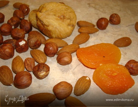 Пока остывает сироп… В миску высыпаем орехи, рекомендую целыми. Затем порезанный крупными кубиками инжир и курагу. Посыпаем сверху всеми специями, затем какао-порошок (если вы его используете, а не шоколад), затем муку и все хорошо перемешиваем. 
Заливаем все это теплым сиропом и начинаем трудиться. Перемешиваем руками, т.к. масса будет очень густая и ложка ее просто не возьмет. Трудимся до тех пор, пока масса не станет однородным куском, из которого во все стороны будут торчать орехи и сухофрукты. Если масса не желает становиться куском, а банально разваливается (т.к. мед у всех разный, поэтому и сироп получается у кого-то гуще, у кого-то нет), то просто добавьте ложку теплой воды.
