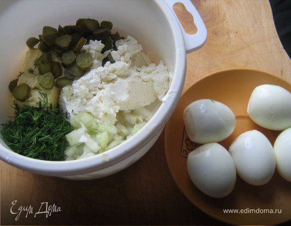 Сваренные в крутую яйца охладить,очистить от скорлупы.В подходящую посуду выложить все ингредиенты:сливочное масло,творожный сыр,мелко нарезанный лук,нарезанные корнишоны,