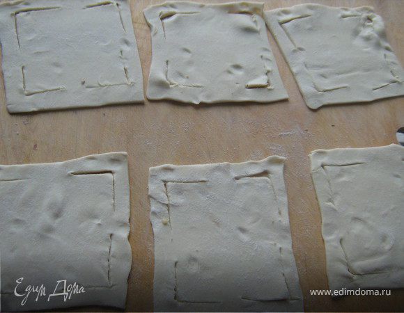 Тесто разморозить,дать немного постоять в тепле,раскатать в пласт,разрезать пласт на квадраты и каждый квадрат слегка надрезать по уголкам