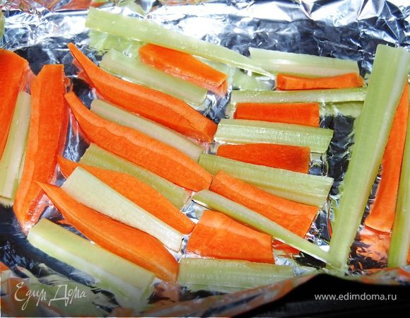 Овощная подушка: морковь и сельдерей очистите, нарежьте на брусочки. Форму застелите фольгой, оставив свободные концы, чтобы потом накрыть ими рыбу. Выложите, чередуя морковь с сельдереем. Посолите и поперчите.