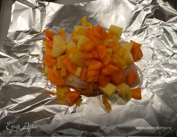 В центр листа фольги (25-30 см) выкладываем слоями: рыбу, лук, картошку, помидоры, болгарский перец, морковь. Все слои немного солим и перчим.  