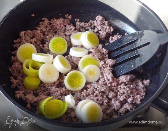 Лук-порей почистить, помыть и нарезать кольцами. Фарш обжарить в разогретом масле до рассыпчатого состояния, посолить, поперчить. Добавить лук и продолжить жарить еще минуты 3.