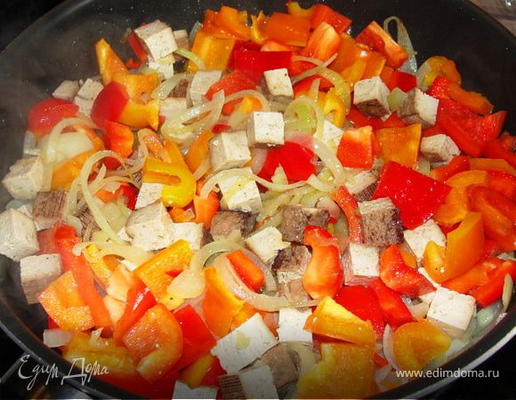 Обжариваем лук на подсолнечном масле до прозрачности и добавляем к нему болгарский перец, перчик чили и тофу. Немного обжариваем всё вместе.