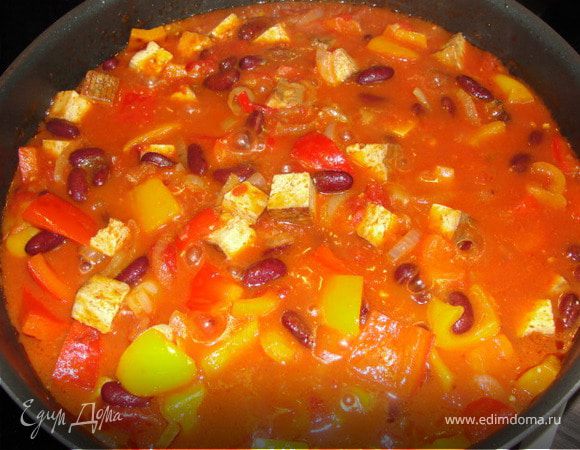 Добавляем томаты. Приправляем сладкой паприкой, кумином, солим и перчим. Тушим 10 минут, после чего выкладываем фасоль и тушим ещё 5 минут. Готово.