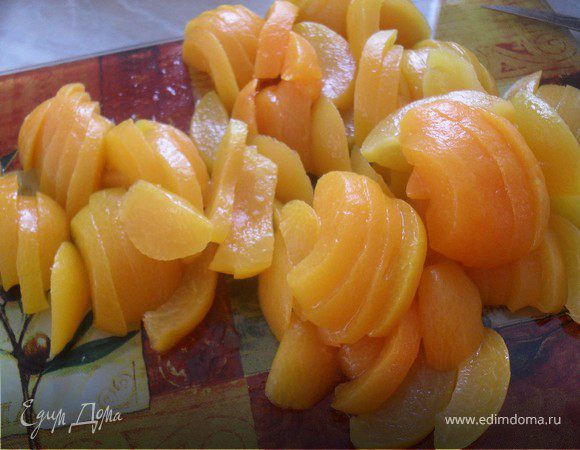 Пока тесто охлаждается, сделаем начинку.Для этого сольем сироп с абрикосов в чашечку (он нам пригодиться), а абрикосы порежем на кусочки.В воде растворить желатин.Когда он набухнет, влить в него сироп от абрикосов и довести до кипения на плите.