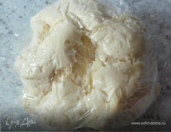 Готовим тесто. Для этого смешиваем 100г масла, воду и муку до однородного состояния. Заворачиваем в пищевую пленку и кладем в холодильник на 30 минут.