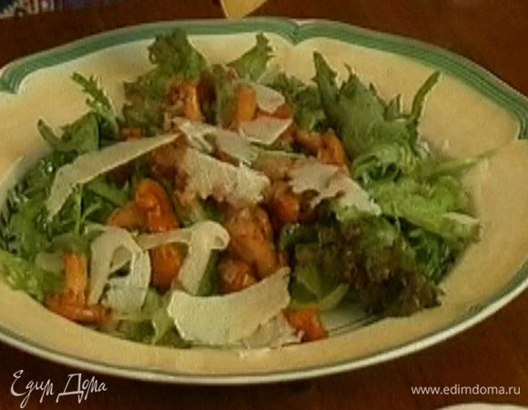 Выложить на листья салата лисички, сверху посыпать хлопьями сыра. Подавать салат теплым.