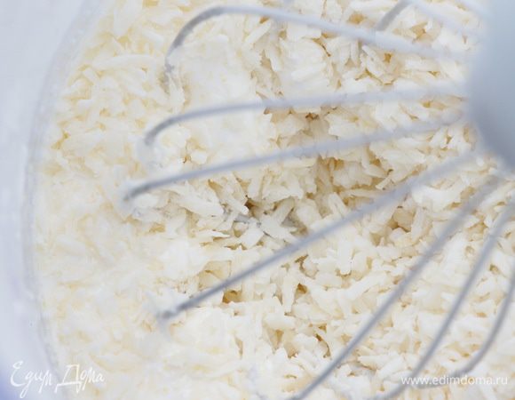 Продолжая взбивать, всыпать кукурузную муку и кокосовую стружку.