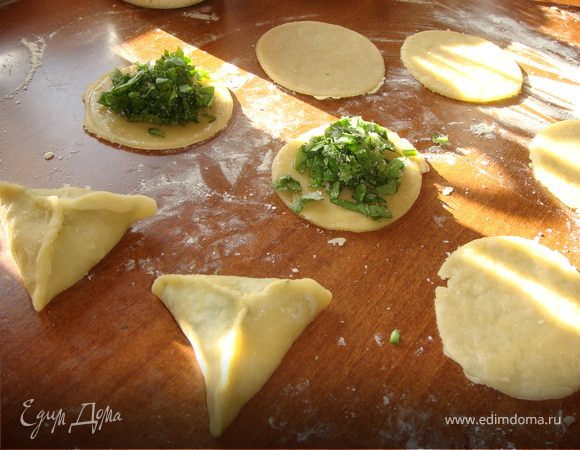 С помощью чашки или мисочки вырезаем круг, раскладываем начинку и соединяем концы с трех сторон. Для того чтобы при выпекании наши пирожки не открылись концы можно смазать водой или яйцом. 
