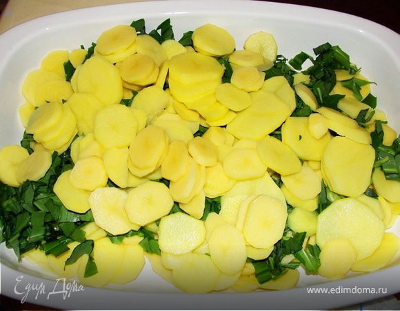 Почистить и помыть картофель, порезать тонкими кружками. Смешать в форме для запекания с черемшой.