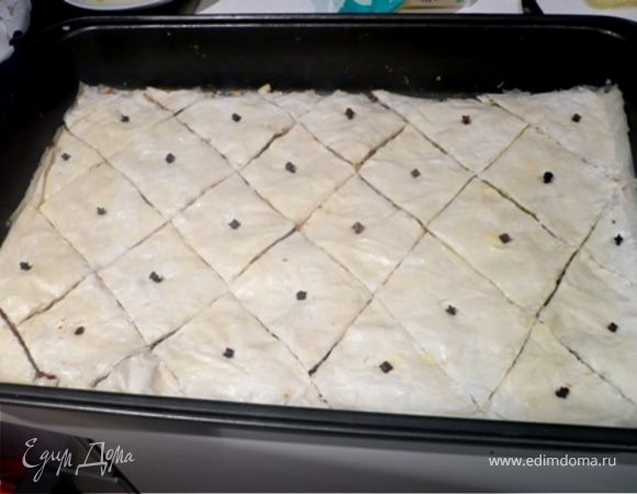 Последний лист чуть увлажнить водой, чтобы не высыхал и маленьким ножом нарезать ромбиками (ок. 6х6 см.). В центр каждого воткнуть по гвоздичке. Выпекать в разогретой до 180 С 25-30 мин. или до нежно-золотистого цвета. 
