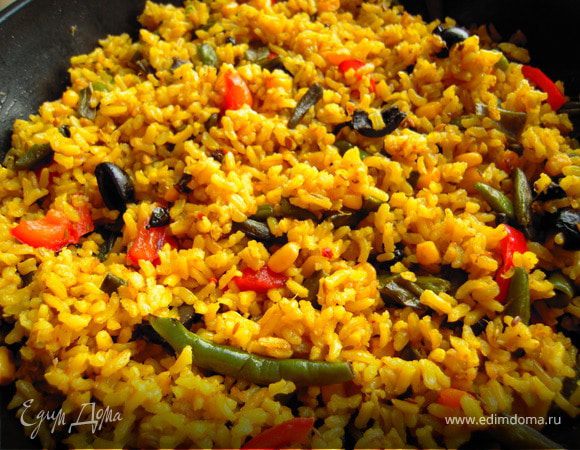 Отвариваем рис со специями. В это время на разогретой сковороде с оливковым маслом готовим стручковую фасоль, в конце готовки слегка обжариваем и добавляем порезанные сладкий перец и перец чили, кукурузу. Слегка обжариваем все ингредиенты. Добавляем приготовленный отдельно рис. Тщательно перемешиваем, прогреваем.  Кладём порезанные пополам маслины, ещё раз мешаем. Даём постоять буквально минутку под крышкой и выключаем. Паэлья готова. Приятного аппетита! :)
