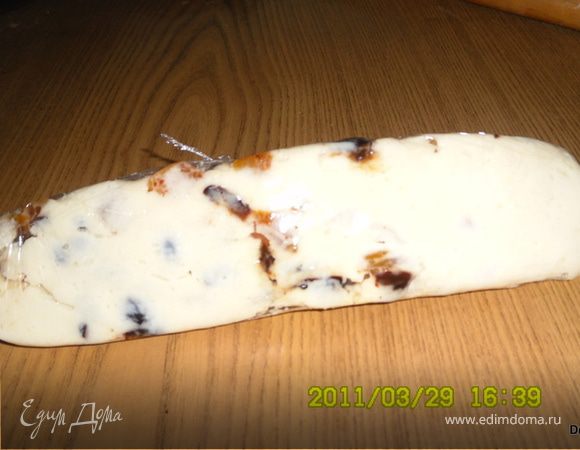 Аккуратно вылаживаем сыр на пищевую пленку(если образовалась жидкость - слейте ее) и раскатываем пока он горячий.Укладываем,чуть вдавливая сухофрукты и заворачиваем плотно рулетом в пищевую пленку.Даем остыть - и в холодильник.Как застынет - готово!