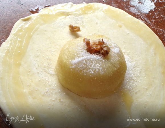 Тесто разделить на 3-4 части и каждую раскатать в виде квадрата. По центру разместить яблоко, в сердцевину заложить изюм, присыпать все яблоко сахаром. Любителям мака можно посоветовать начинить им яблочки, предварительно проварив его минут 10 в кипятке, а затем высушив.
