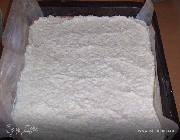 Разъемную форму диаметром 25 - 26 см. застелить бумагой для выпечки и смазать маслом. Насыпать половину теста. Аккуратно выложить начинку, разровнять.