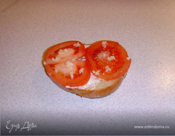 поджаренный бутерброд смазываем (не сильно) сливочным маслом, с помидора снимаем кожицу (делаем на помидоре надрез и заливаем его кипятком на 2-3- мин, он сам из "одёжки" выпрыгнет!) режем и выкладываем на масло. Солим и выдавливаем чеснок (тут уж на любителя).
