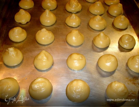 Тесто:
Тесто для профитролей я взяла общепринятое, но воду заменила на молоко. Мне кажется, что на молоке они получаются более крепенькими. Итак, готовим заварное тесто. Молоко соедините с солью и маслом, доведите до кипения и при постоянном помешивании засыпьте просеянную муку. Прогрейте смесь в течение 2 минут, непрерывно перемешивая до исчезновения комков муки. 
Заварную массу снимите  с огня и дайте минут 10 остыть. Затем поочередно вбивайте в смесь яйца, каждый раз размешивая до однородного состояния, но не взбивайте. Готовое тесто представляет собой вязкую массу.
Противень смажьте тонким слоем сл.масла или маргарина. Если  масла или маргарина будет слишком много, то все донышки у профитролей окажутся дырявыми. Из шприца, кондитерского мешка с насадкой или просто маленькой чайной ложечкой отсаживаем на противень шарики, величиной с грецкой орех. При том, расстояние между шариками должно быть не менее 3-4 см.  Маленькая хитрость: для того, чтобы тесто легче выдавливалось из нашего шприца, мешка или снималось с ложки, надо сначала смочить водой наши инструменты… 
