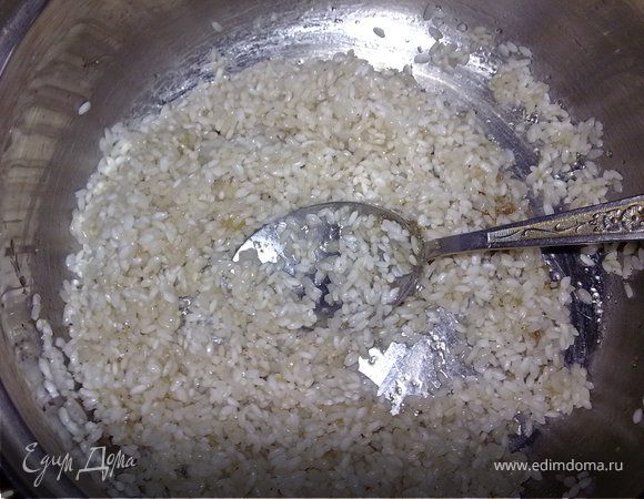 Нагреть оставшееся масло в кастрюле с толстым дном.Рис откинуть на сито,слить воду,положить в масло. Добавить сахар,соль и чёрный перец по вкусу.Тщательно перемешать.