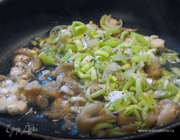 Пока рыбка готовится в духовке - мы готовым сырный соус. Для этого соломкой нарезаем грибы вешанки и лук порей. Обжариваем на оливковом масле 5-10 минут на среднем огне.