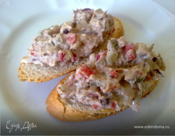 Тунец раздавить вилкой и смешать с соленым огурцом, сладким перцем и красным луком. Чеснок выдавит через пресс и смешать с майонезом и все вместе перемешать. Масса по консистенции должна быть как густая паста. Уложить салат на ломтики свежего багета.