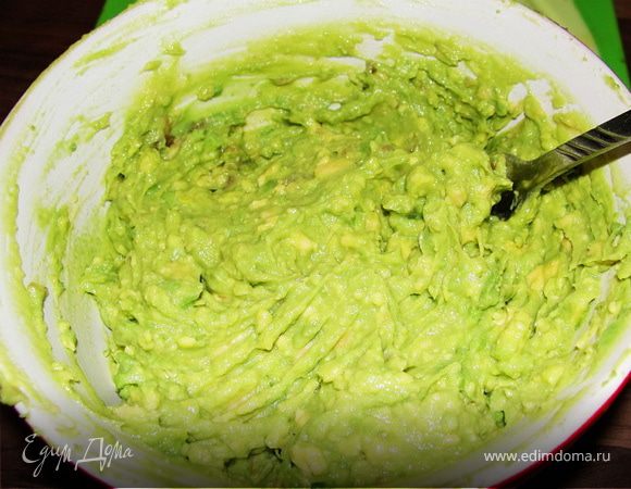 Авокадо разрезать на пополам. Снять кожицу и порезать кубиками. После помять вилкой, добавить лимонного сока.