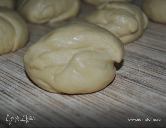 Подошедшее тесто разделить на 12 частей, скатать из каждой шарик и оставить отдохнуть на 10 минут.