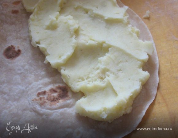 На одну половину лепешки уложить картофельную начинку, согнуть лепешку пополам и накрыть начинку второй половиной. Чтобы лепешки не ломались на изгибе, их надо начинять горячими. 
