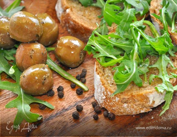Нарежем свежий ржаной багет на ломтики толщиной 1,5 см и обжарим их в тостере или духовке. Теперь польем их ароматным чесночным оливковым маслом и посыпим молотым черным перцем. Сверху положим горсть пряной рукколы, предварительно помяв ее руками немного. К таким кростини идеально подойдут соленые оливки. Купите грамм 200 отборных сицилийских оливок, засоленных с пряными травами, иногда в пост тоже должны быть свои деликатесы. Теперь откусите хрустящий хлеб, добавьте к нему восхитительную оливку и насладитесь этим поистине тосканским вкусом!