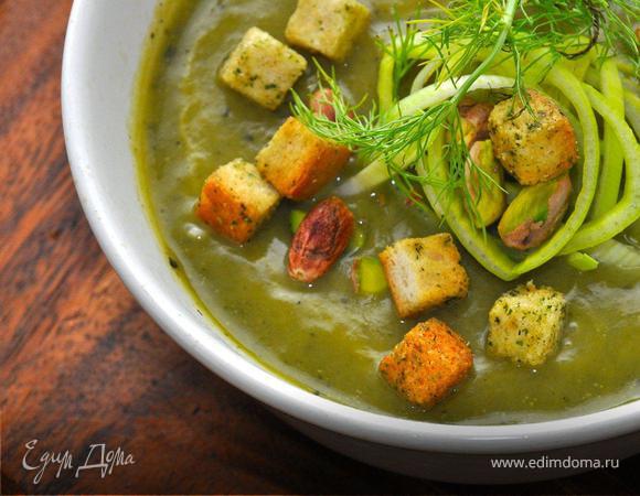 Пора подготовить наш вкуснейший зеленый суп к подаче. Нам понадобятся крутоны, которые очень легко приготовить из черствого хлеба. Для этого нарежем хлеб небольшими кубиками, польем оливковым маслом и посыпим сухим укропом. Разложим хлеб на противне и отправим в прогретую духовку, пока хлеб не подсохнет. Теперь наливаем суп в суповые чашки и украшаем тонкими колечками порея, зеленью фенхеля, горстью обжаренных фисташек и укропными крутонами. Приятного аппетита, продолжение следует!