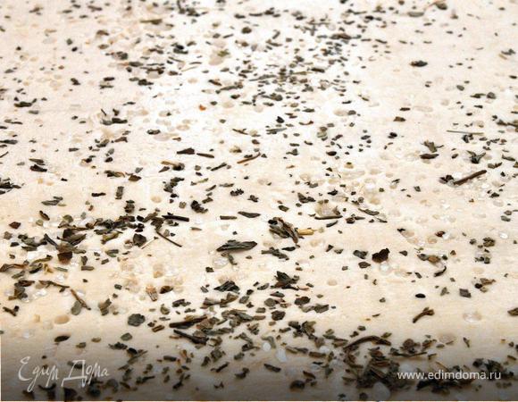 Теперь подготовим тесто. Я брал готовое бездрожжевое слоеное тесто (постное). Лист теста посыпим крупной морской солью и сухим базиликом. После чего слегка раскатаем скалкой и нарежем на полоски по количеству черенков спаржи.