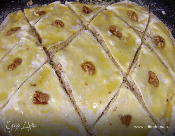 Далее берем наше тесто...чуть уминаем его и разрежаем на 7 частей...И начинаем берем первую часть раскатываем в тонкий пласт, выкладываем на смазанный сливочным маслом противень...Смазываем сам пласт растопленным сливочным маслом и хорошо (обильно) засыпаем начинкой...Теперь следующий пласт раскатываем, смазываем растопленным маслом и снова посыпаем начинкой.. И так все слой...Верхний слой смазываем взбитым желтком и разрезаем на большие ромбики.. В середину каждого ромба кладем по орешку...