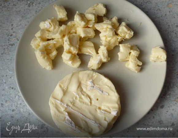 Тем временем смазать маслом форму для запекания (26см). С камамбера снять корку и мелко порезать.