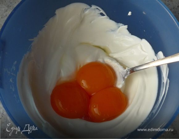 Сметану хорошо перемешать, добавить желтки. Посолить, поперчить, бросить петрушку. Все хорошо перемешать.
