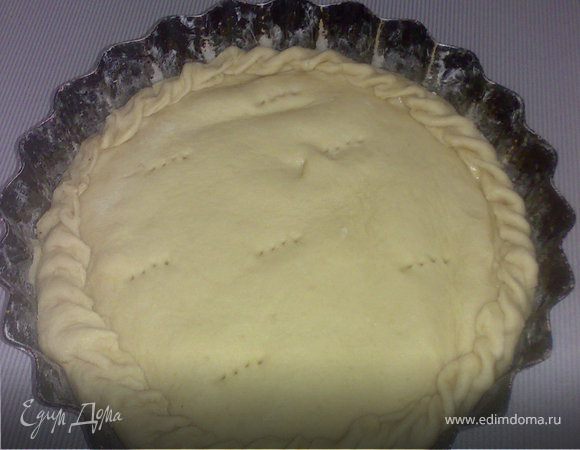 Берем , желательно, разъемную форму и смазываем ее сливочным маслом. Тесто необходимо разрезать на две неравные части. Большую раскатать на доске, посыпанной мукой, и положить в форму. Края пласта нужно высоко поднять. Сверху выкладываем начинку и закрываем вторым раскатанным куско теста. Очень тщательно защипите края и сделайте несколько проколов на поверхности пирога. 