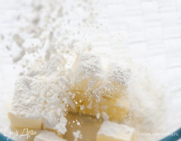 Предварительно охлажденное сливочное масло порубить с мукой, сделать холмик, а в нем углубление.