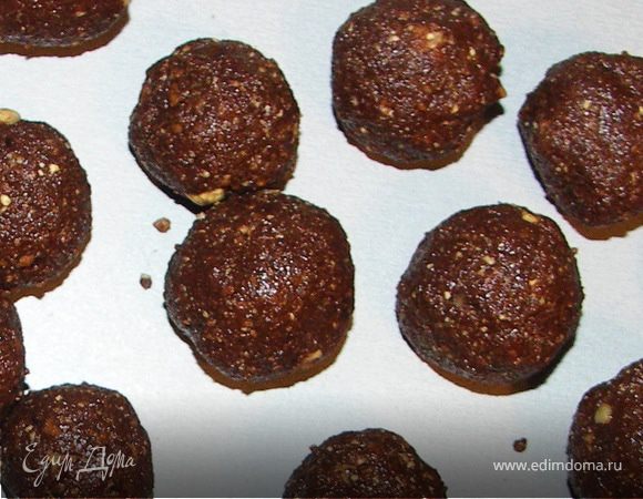 Шоколад растопить на паровой бане.Чернослив измельчить в блендере(если понадобится добавить 2-3 ложки сиропа).Перемешать чернослив и шоколад.Добавить орехи.Ещё раз тщательно перемешать и добавить столько сиропа,сколько понадобится для нужной консистенции.Слепить шарики.